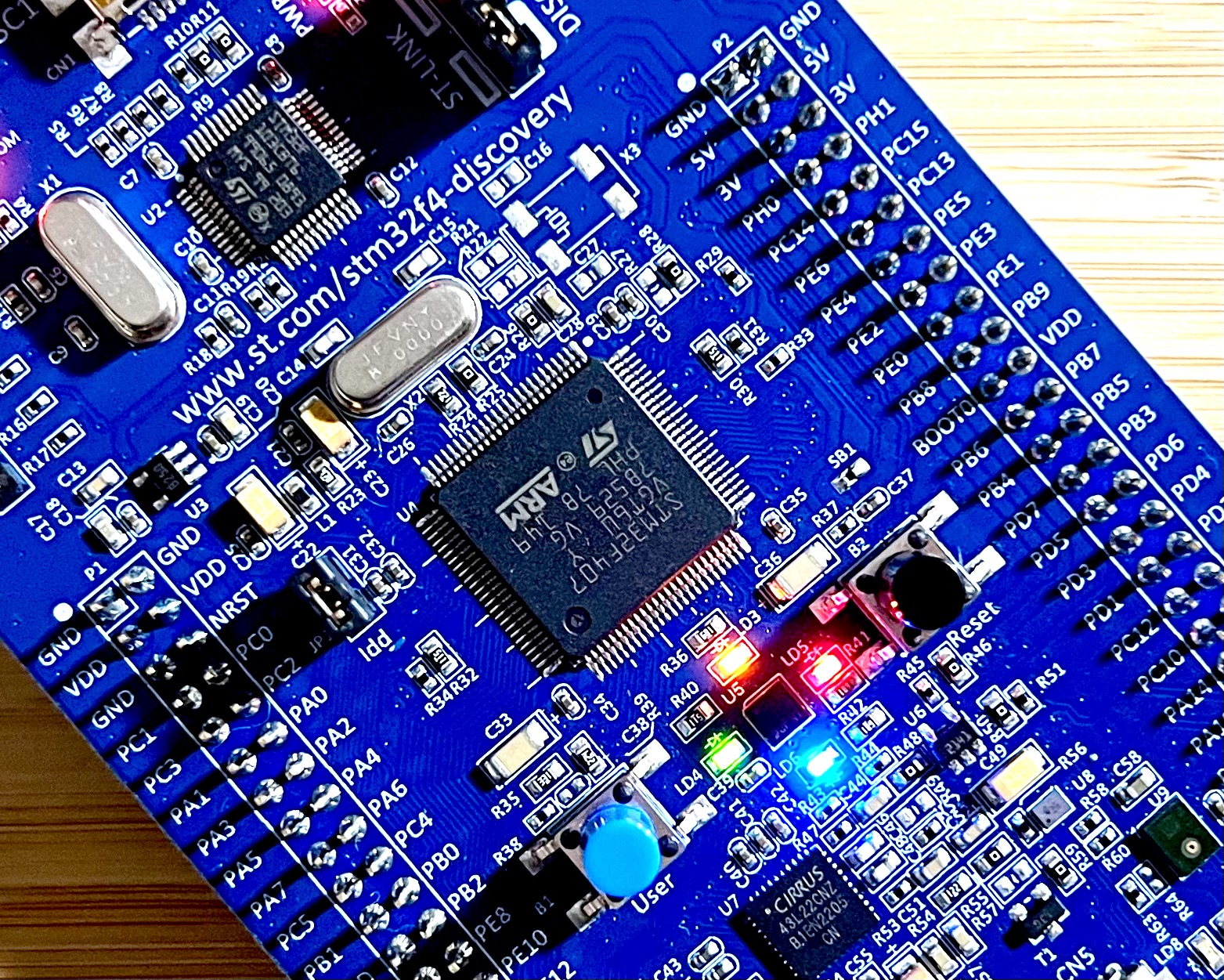 A close up of an STM32F407G-DISC1 developer circuit board, centred on the ARM MCU and 4 user controllable LEDs.